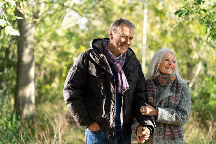 smiling couple walking in woodland